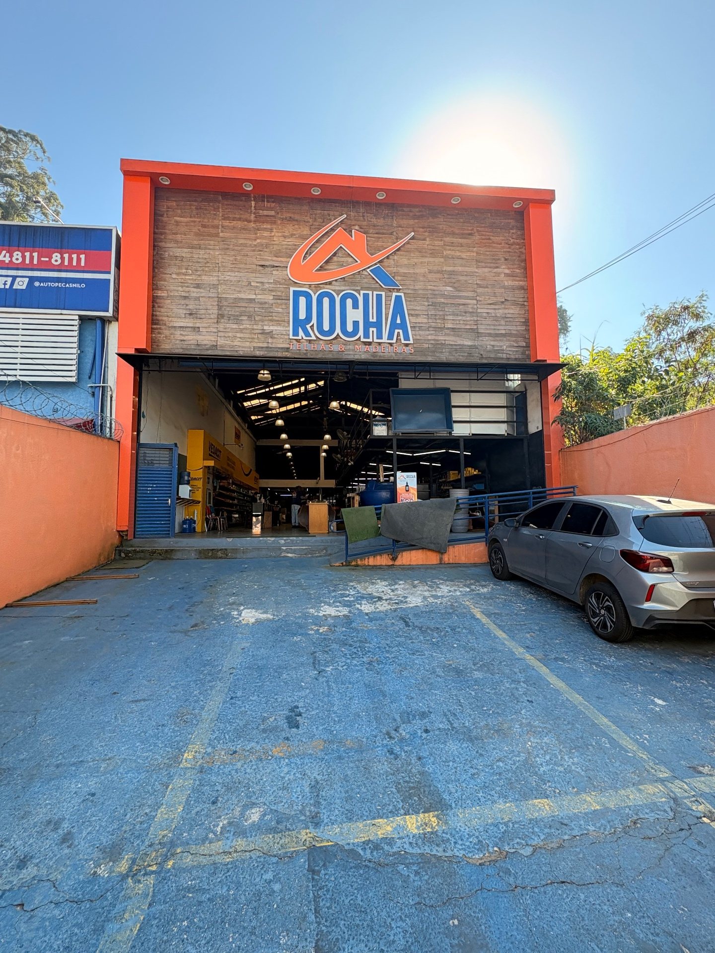Pátio logístico da Rocha Telhas com caminhões carregando madeira e telhas